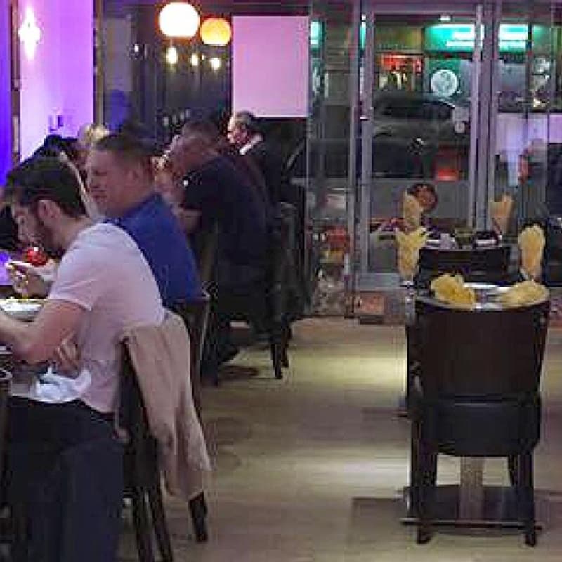 A full dining room, diners at every table along the window.