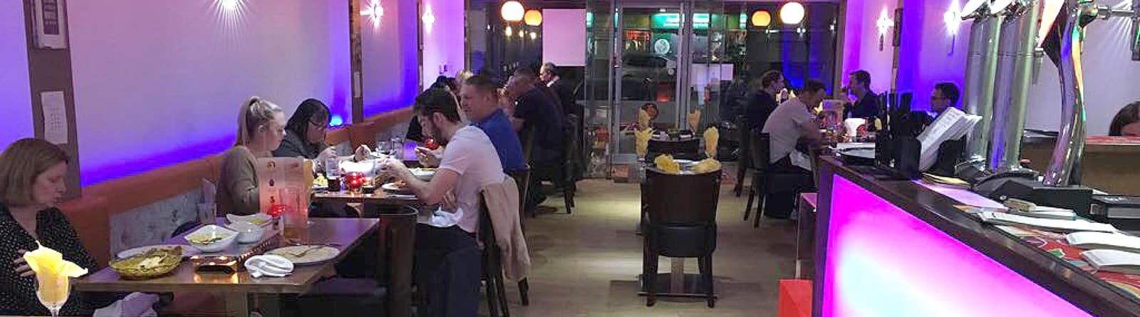 A full dining room, diners at every table along the window.